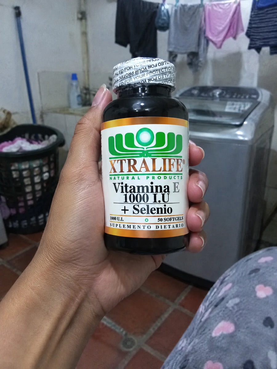 Mano sosteniendo Vitamina e y selenio 1000 UI